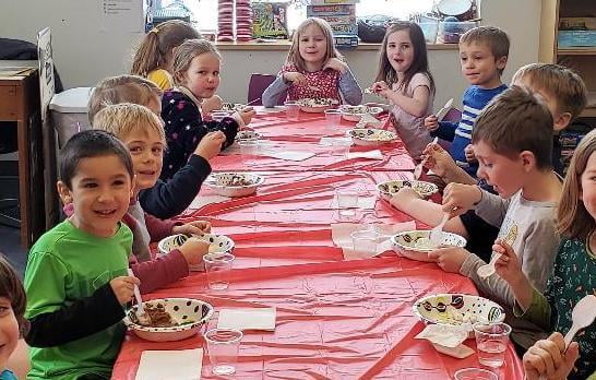 Children eating together at a long table